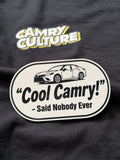 A close-up of a sticker featuring a white and black sticker that reads 'Cool Camry! - Said Nobody Ever' with a car illustration, and a yellow and white 'Camry Culture' graphic above it.