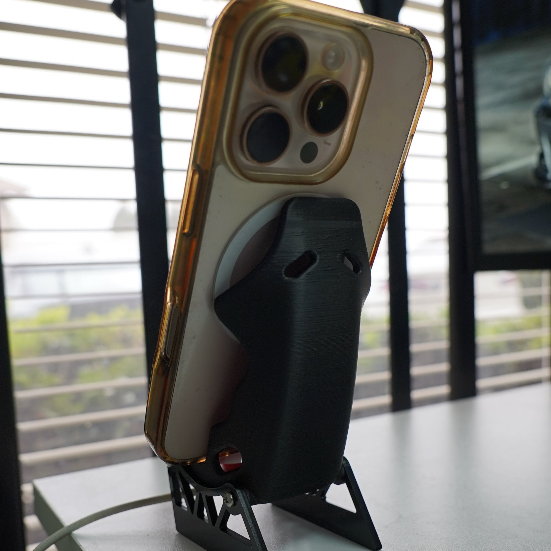 Smartphone with a protective case on a stand against a window background