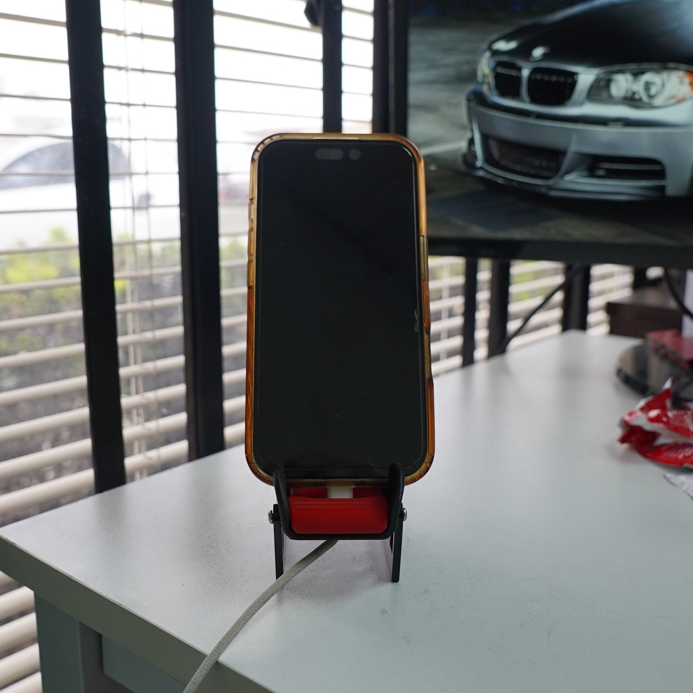 Phone on a stand with a car displayed in the background